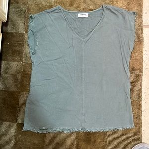 Green top with frayed hem along the shirt bottom and sleeves